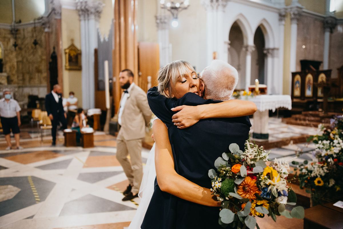 Abbraccio spontaneo in chiesa con il bouquet tra le mani