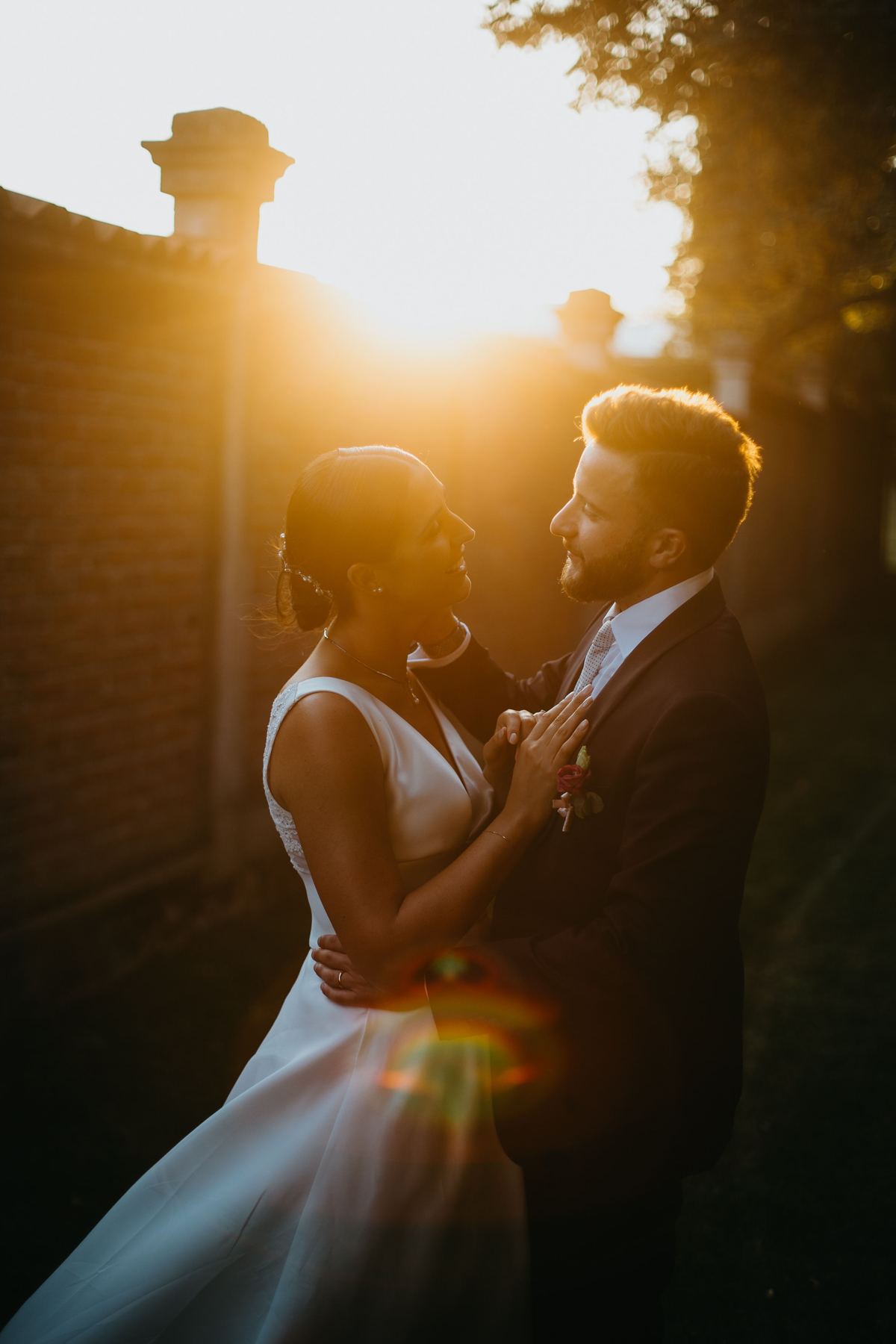Abbraccio romantico degli sposi nella luce dorata